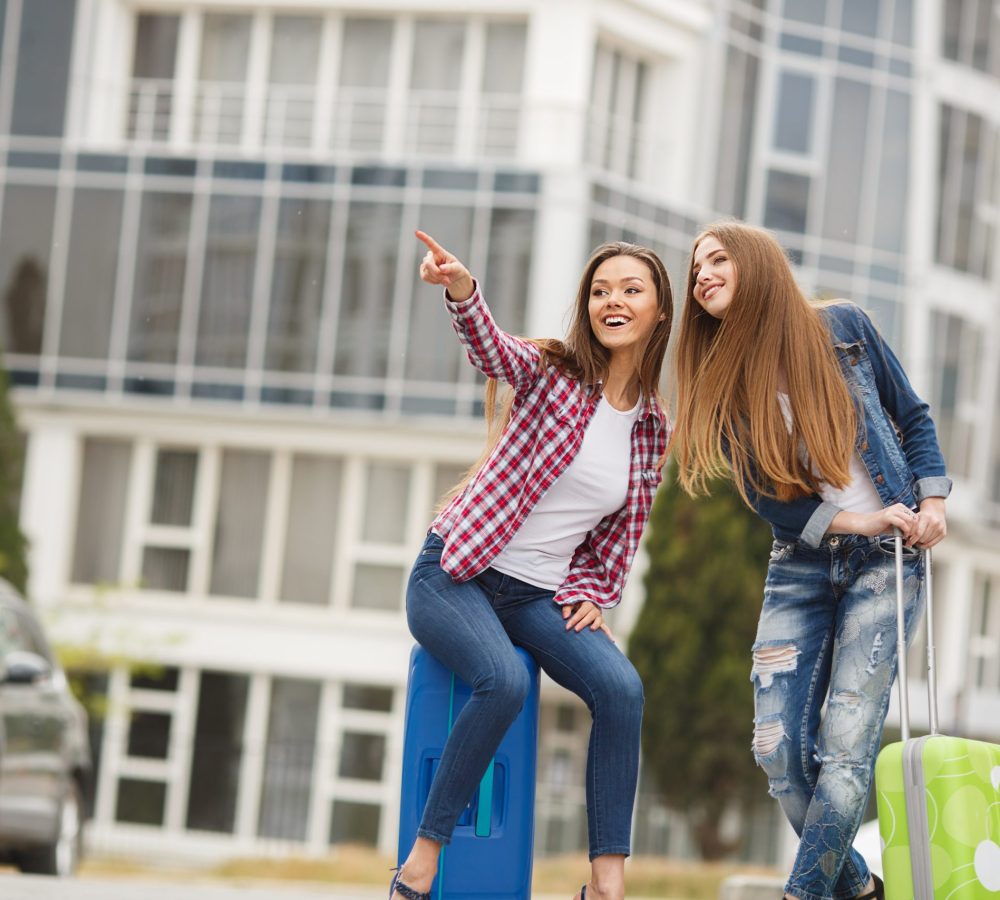 two-young-friends-traveller-with-suitcase